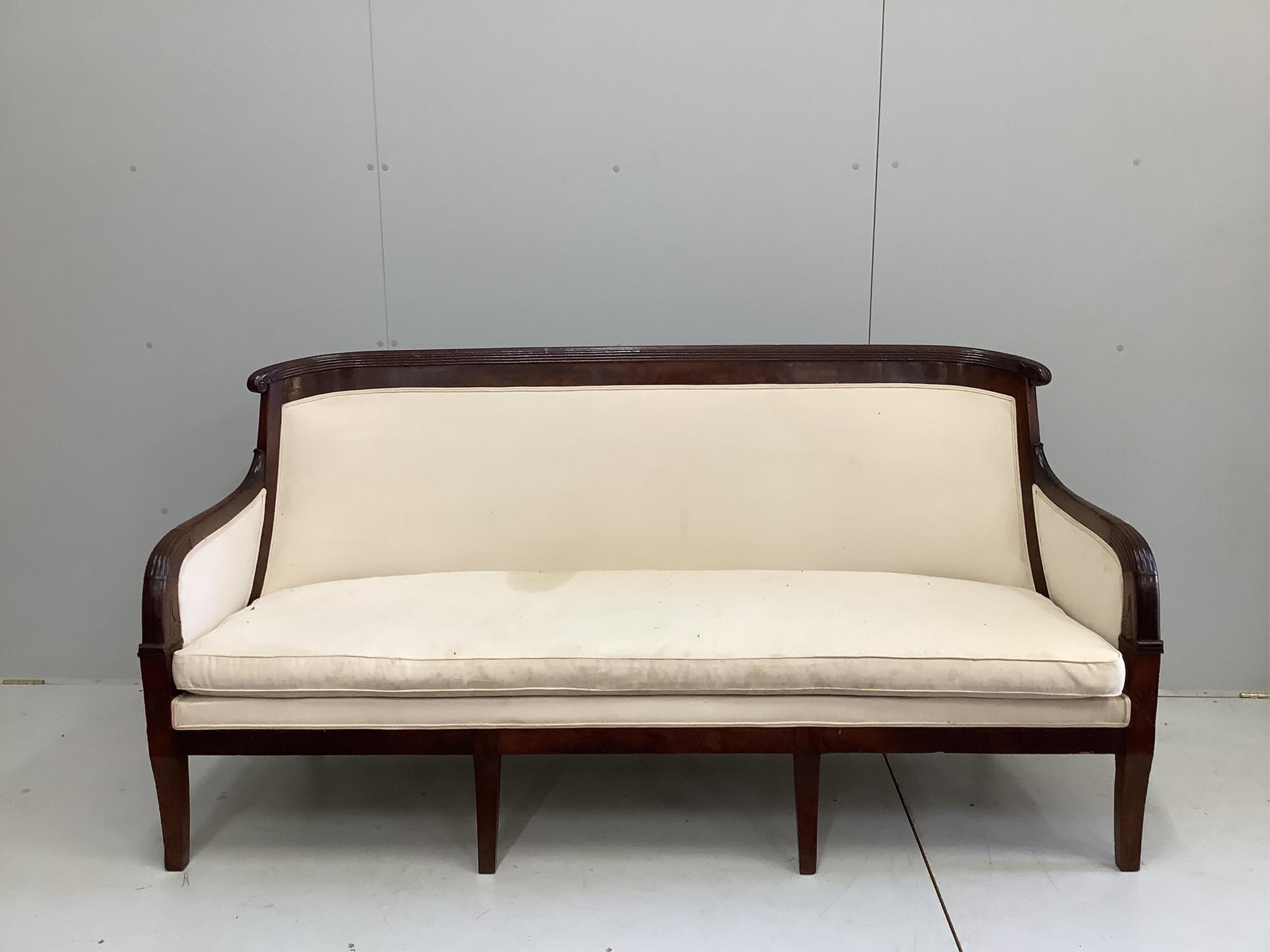 A French Empire upholstered mahogany settee, width 176cm, depth 60cm, height 92cm and a similar fauteuil. Condition - good